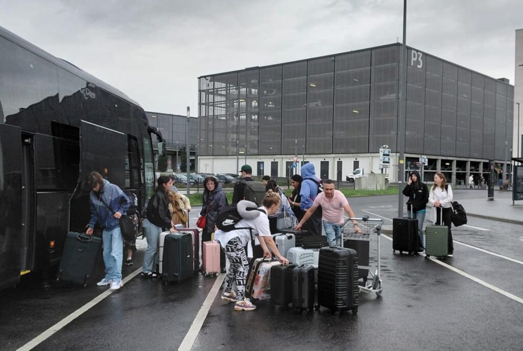 Naale student unload their bus arriving from Germany