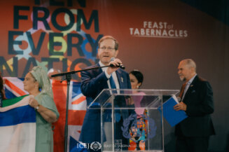 President Herzog speaks to pilgrims from the stage