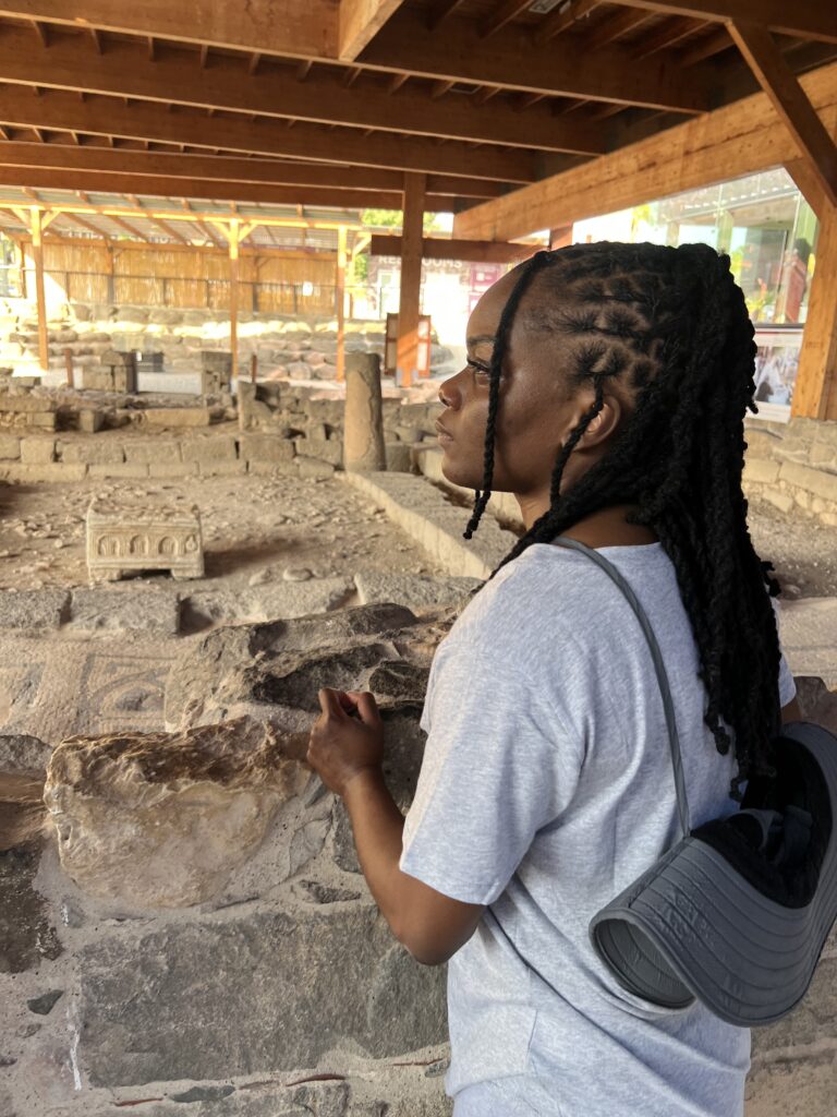 Girl praying in the first-century synagogue of Magdala.