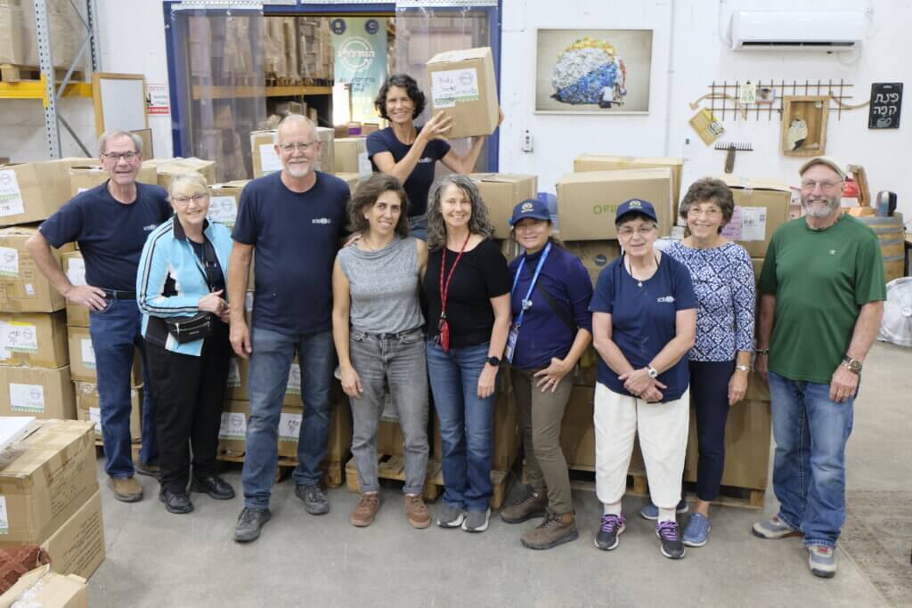 Tour members gather to organize clothes at a distribution center