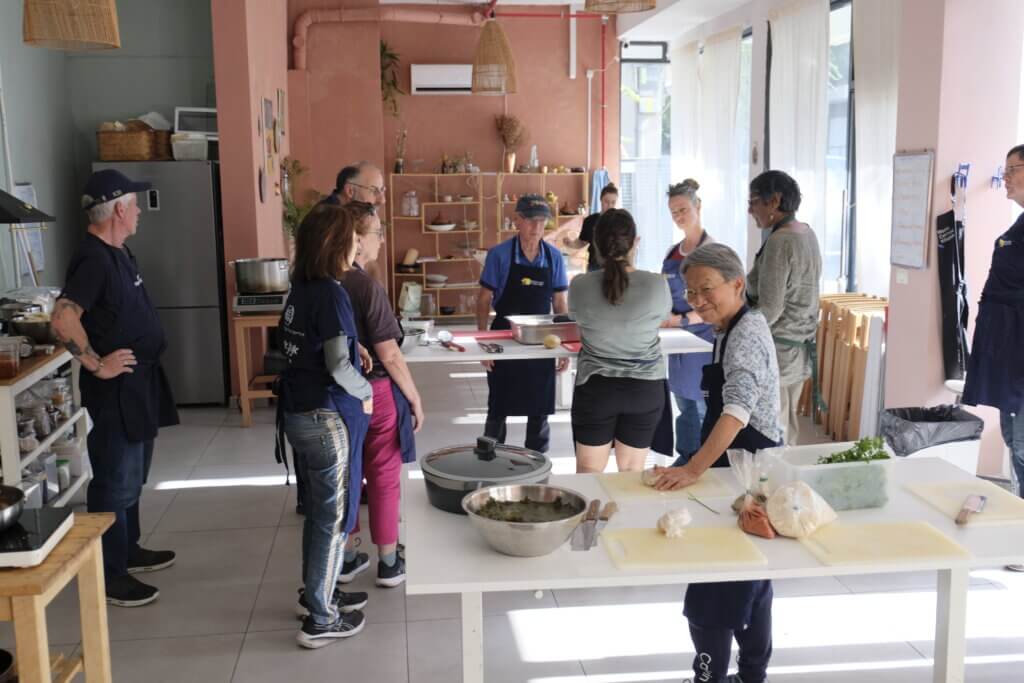 Tour members gather around to help out in the kitchen