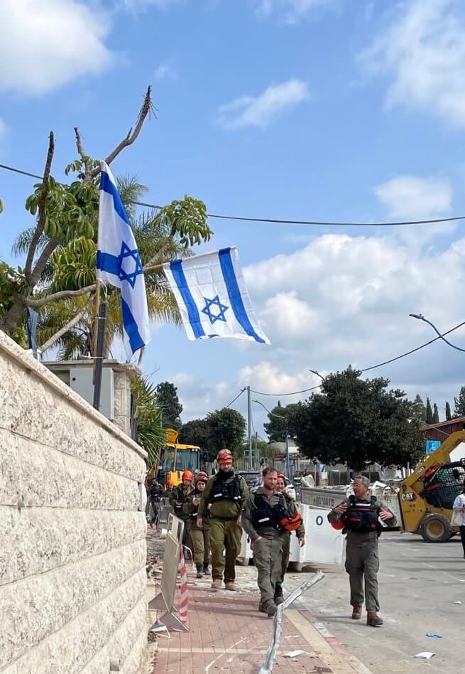 Walking towards the rubble is a group of volunteers