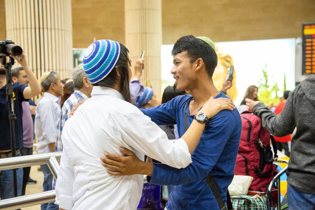 A Bnei Menashe Jewish immigrant is shown receiving a warm welcome at Ben Gurion Airport.