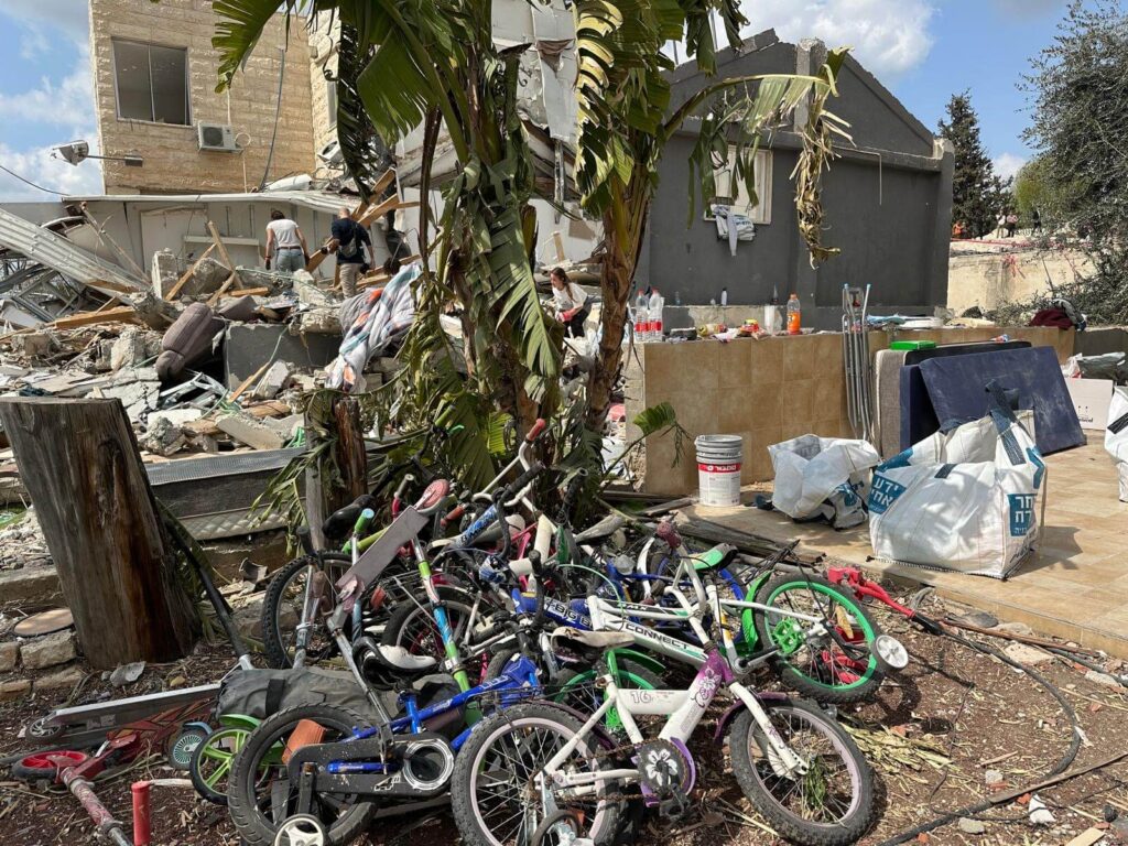 Outside of a destroyed house lay children's bikes