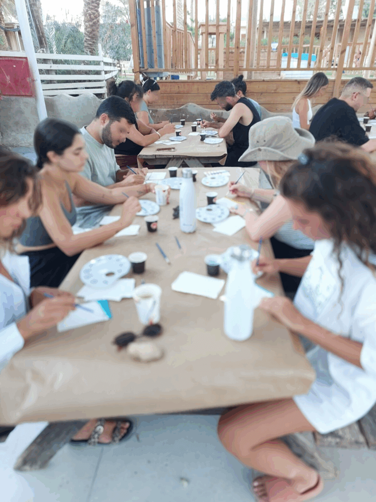 In the photo retreat participants create art at the table outside