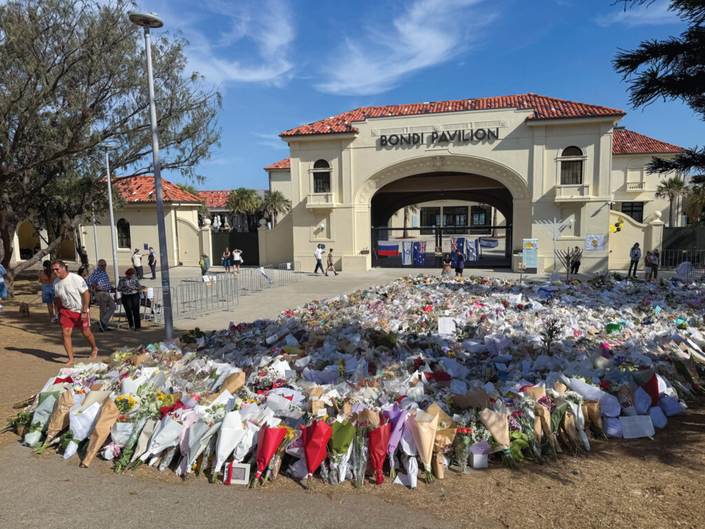 A flower memorial to the Bondi Beach massacre. (Photo: Wikimedia Commons-DaHuzyBru)