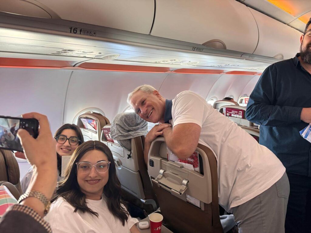 Robert Baxter chats with the Jewish immigrants on the plane